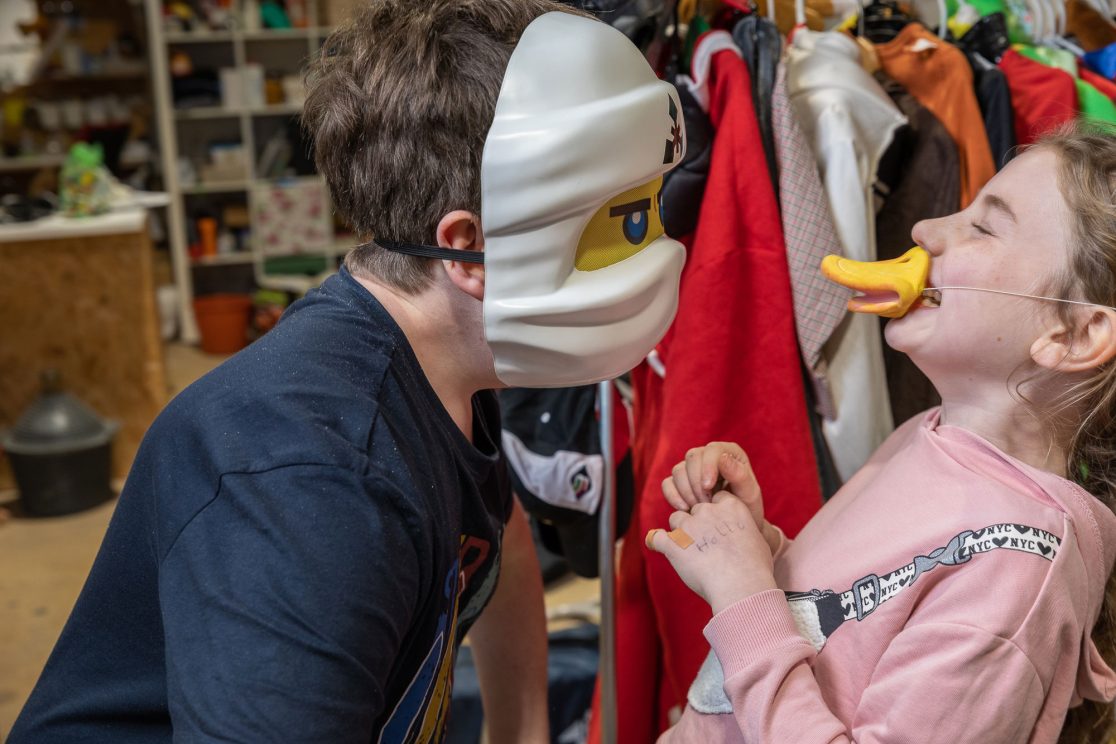 Mädchen und Junge mit Maske lachen