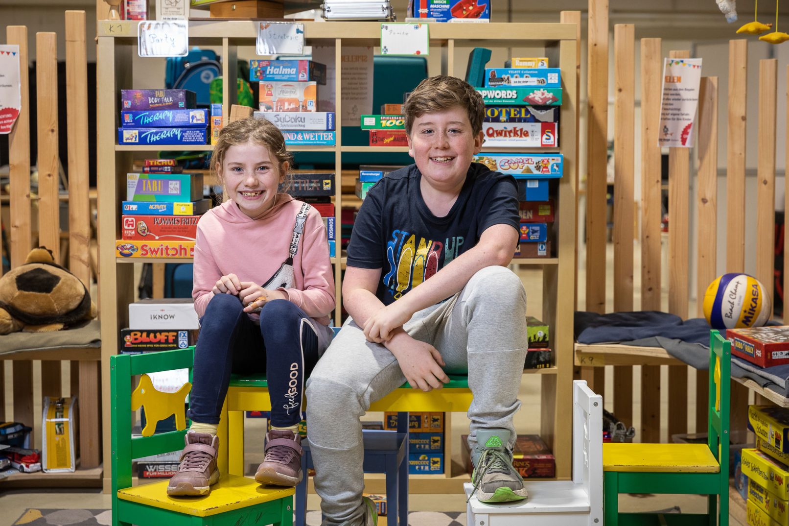 Junge und Mädchen sitzen nebeneinander auf einem Tisch