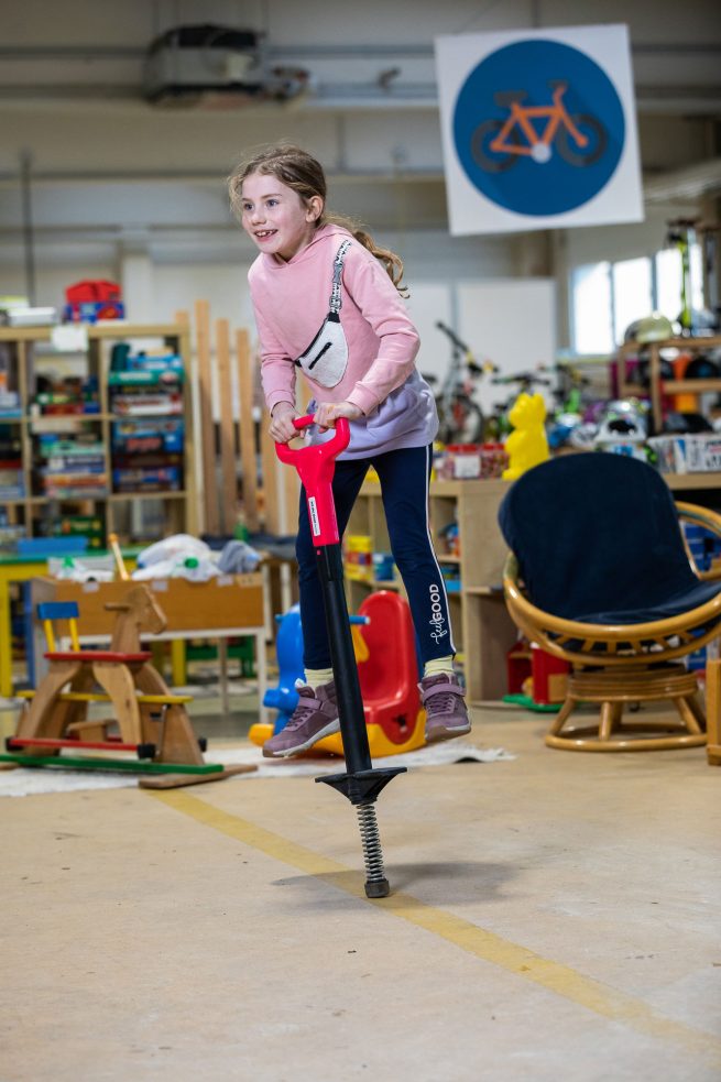 Mädchen hüpft auf Spielgerät durch den Raum